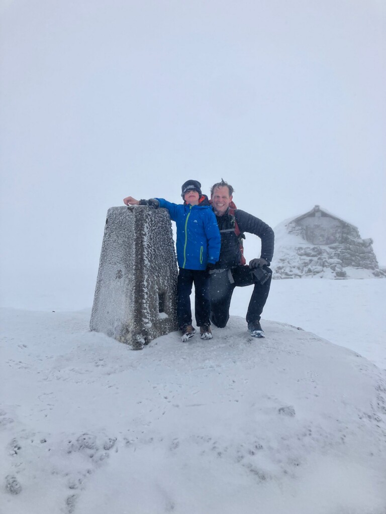 Richard and Arthur Atherton at the snowy summit trig point of Ben Nevis